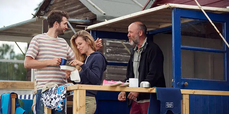 People having lunch outside a beach hut